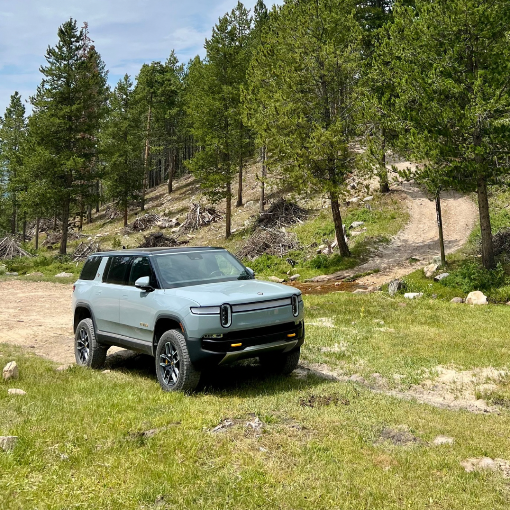 Rivian R1S in a mountain meadow